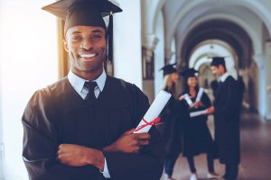 A graduate smiles after earning his diploma