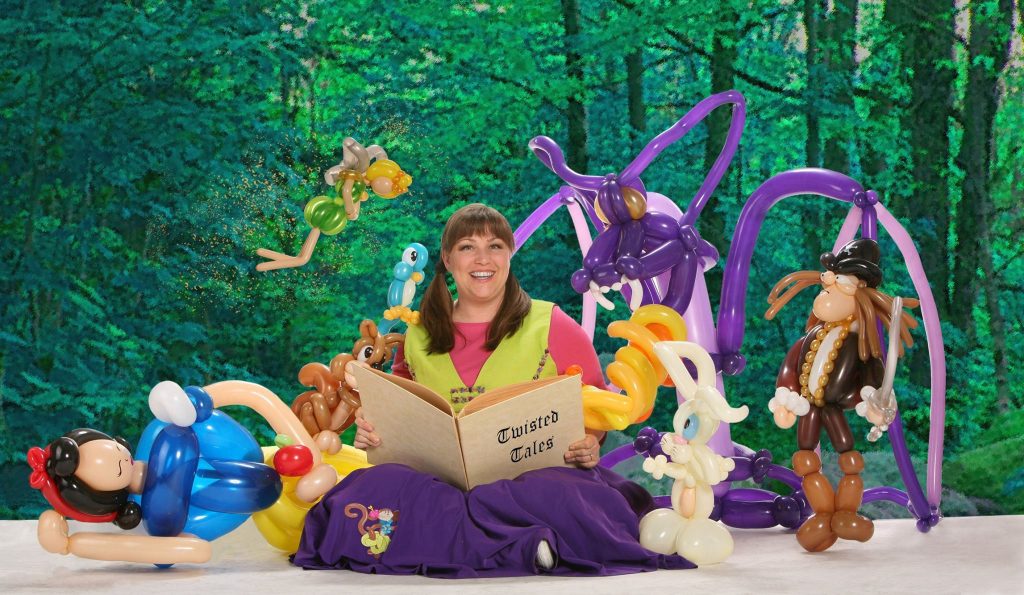 Woman with book, surrounded by balloon figure creations