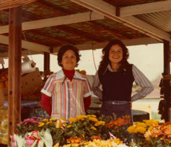 Aged photo of two women at a flower stand