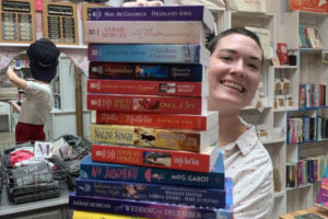 woman holding a stack of books