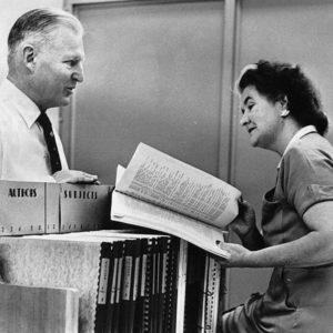 Two staff members reviewing first children’s book catalog, 1953