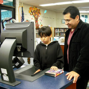 Father and son using self-checkout machine at El Camino Real Library, 2010
