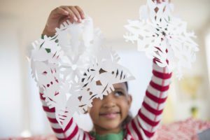 child with paper snowflakes