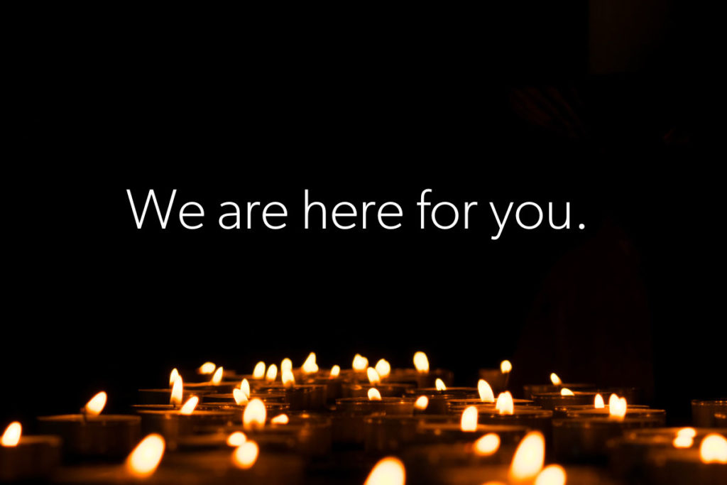 Candles on black background - We are here for you.