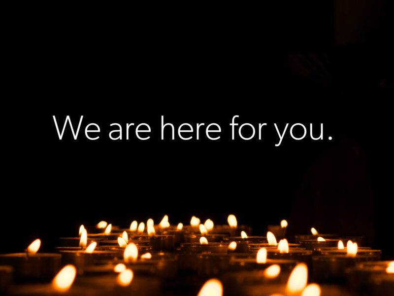 Candles on black background - We are here for you.
