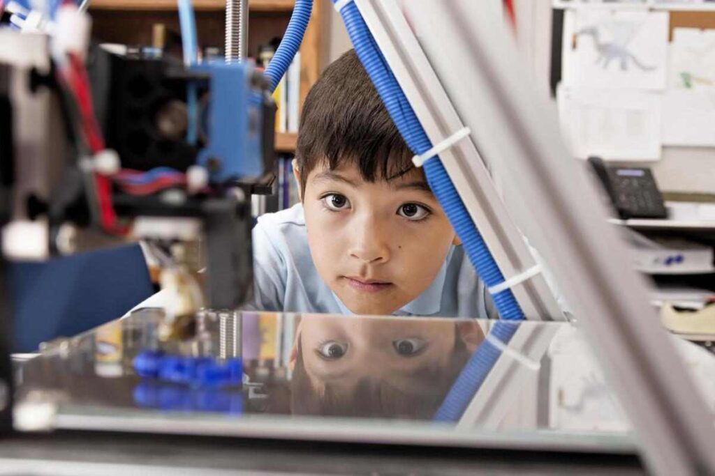 child looking at 3-d printer