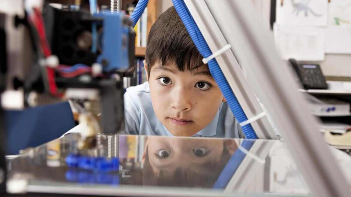 child looking at 3-d printer