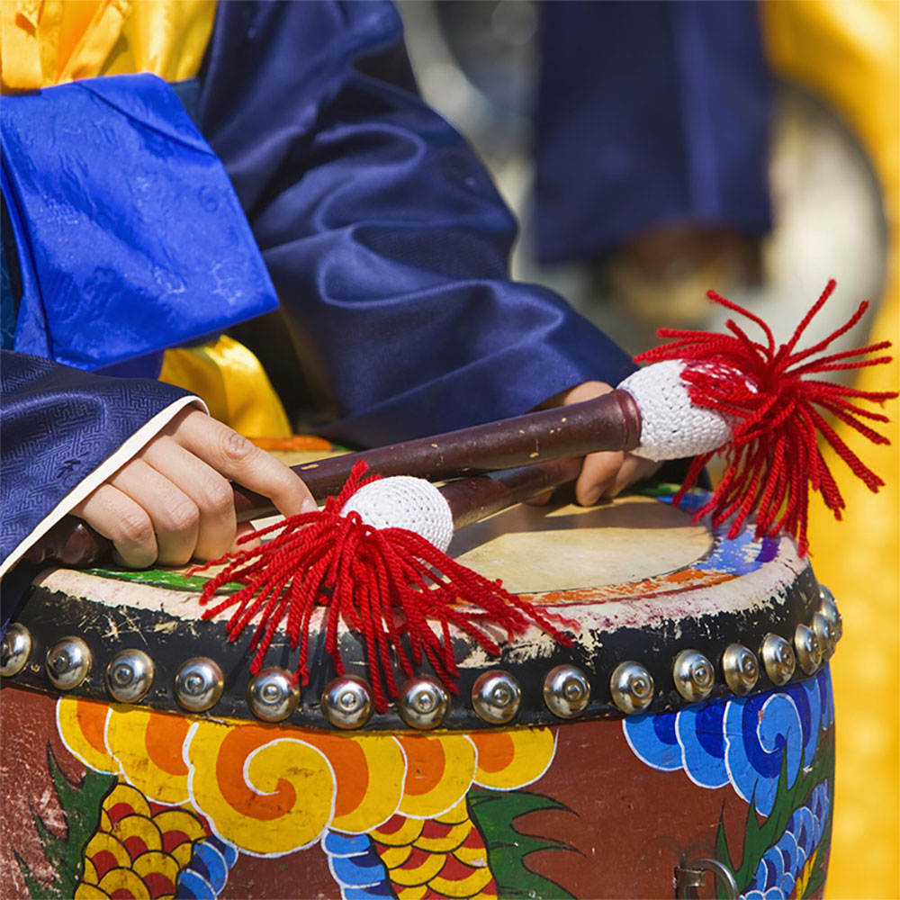 Person playing a colorful drum