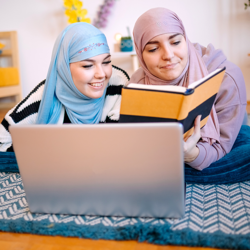 women with headscarves reading a book together