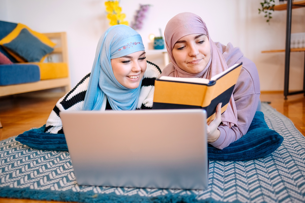 young Muslim women reading a book