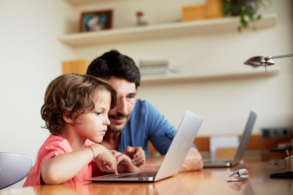 Adult and child using a computer to learn