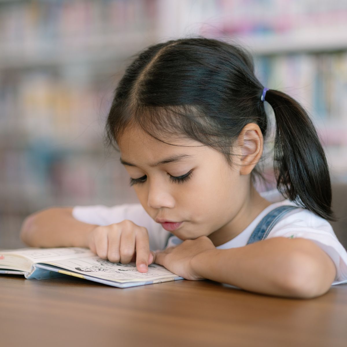 young girl reading on Dia de los Ninos