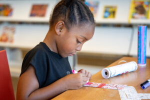 child decorating a bookmark