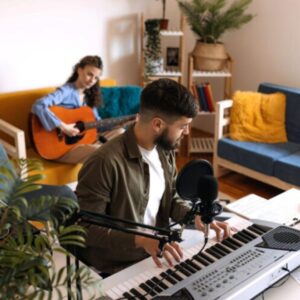young man playing an electric keyboard with young woman playing an acoustic guitar