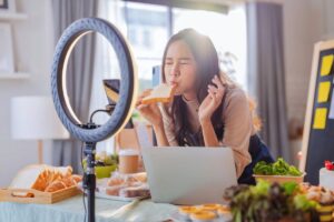 Woman filming herself tasting bread