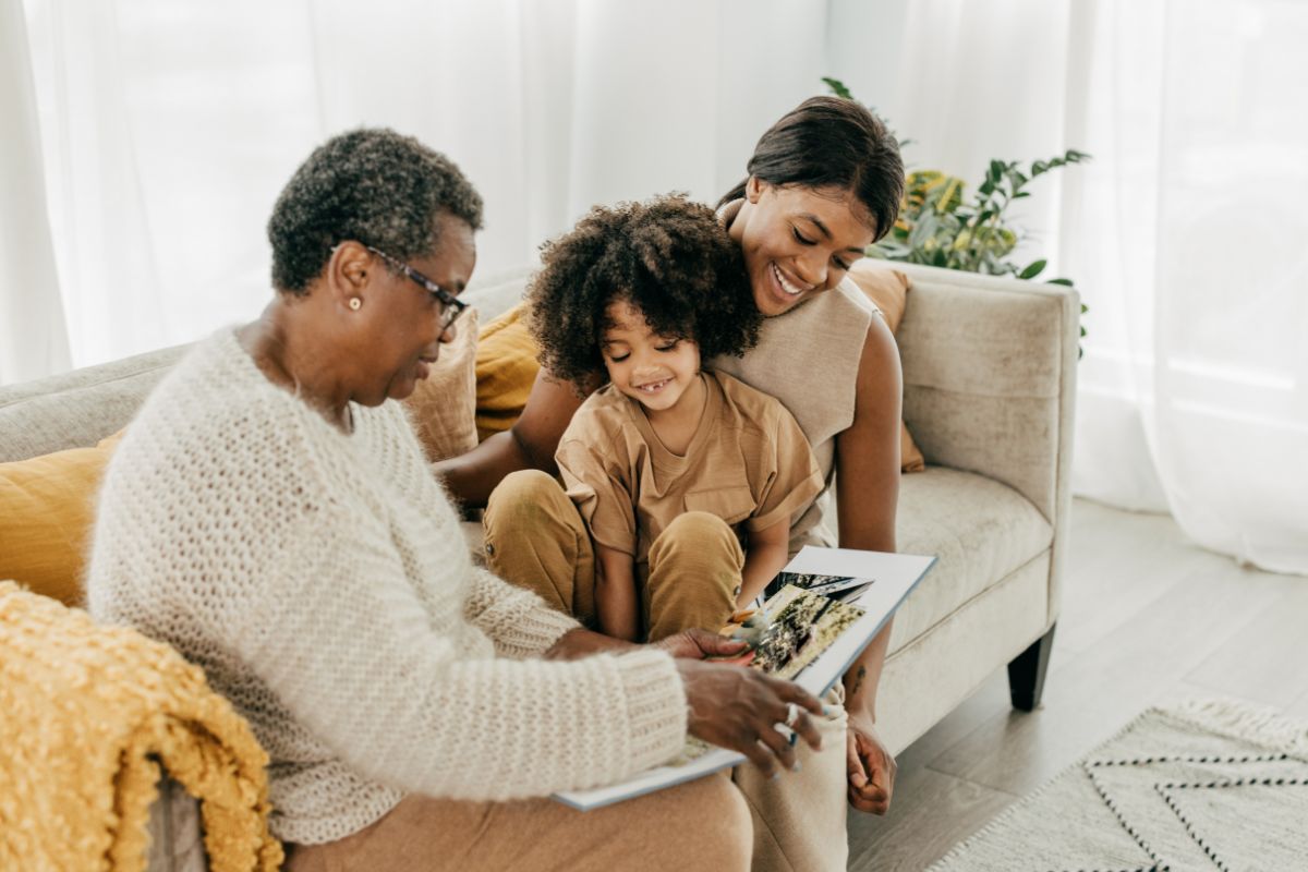 three generations of women looking at a book
