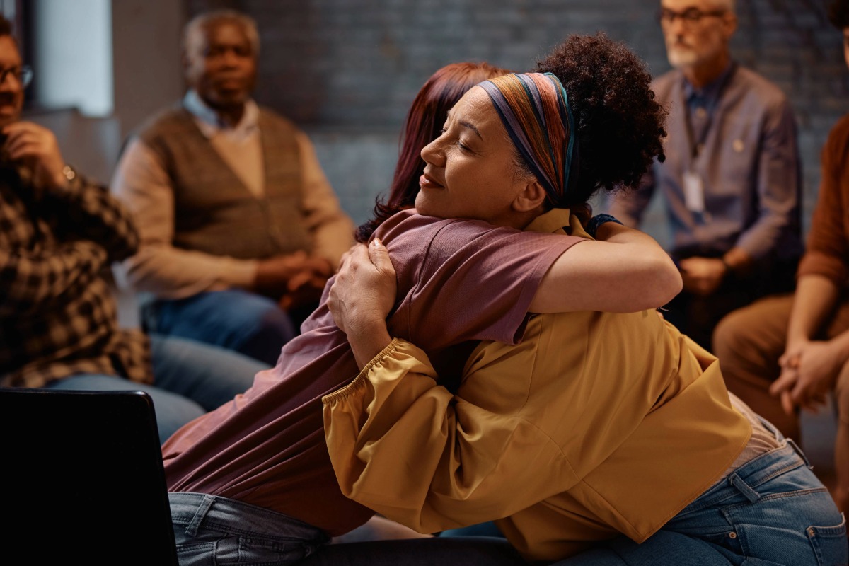 women embracing during a group counseling session