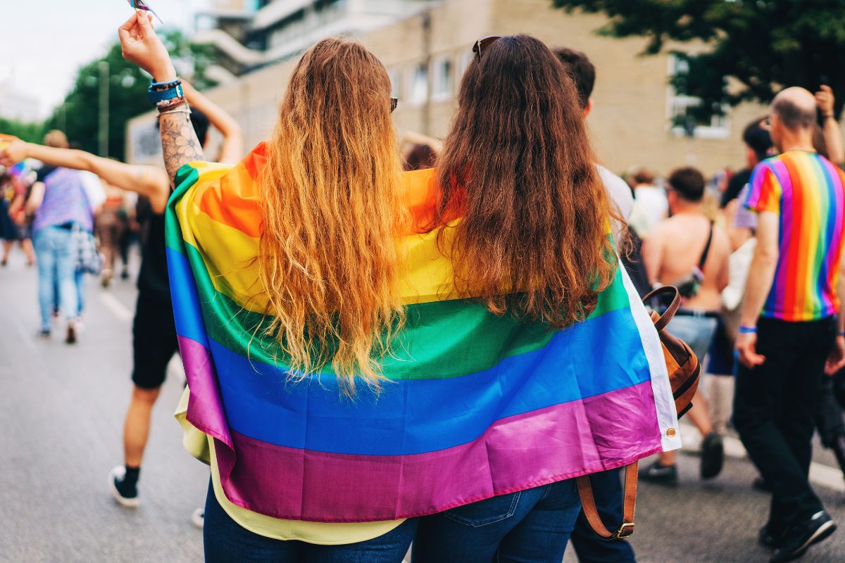 Woman with a pride flag over their shoulders