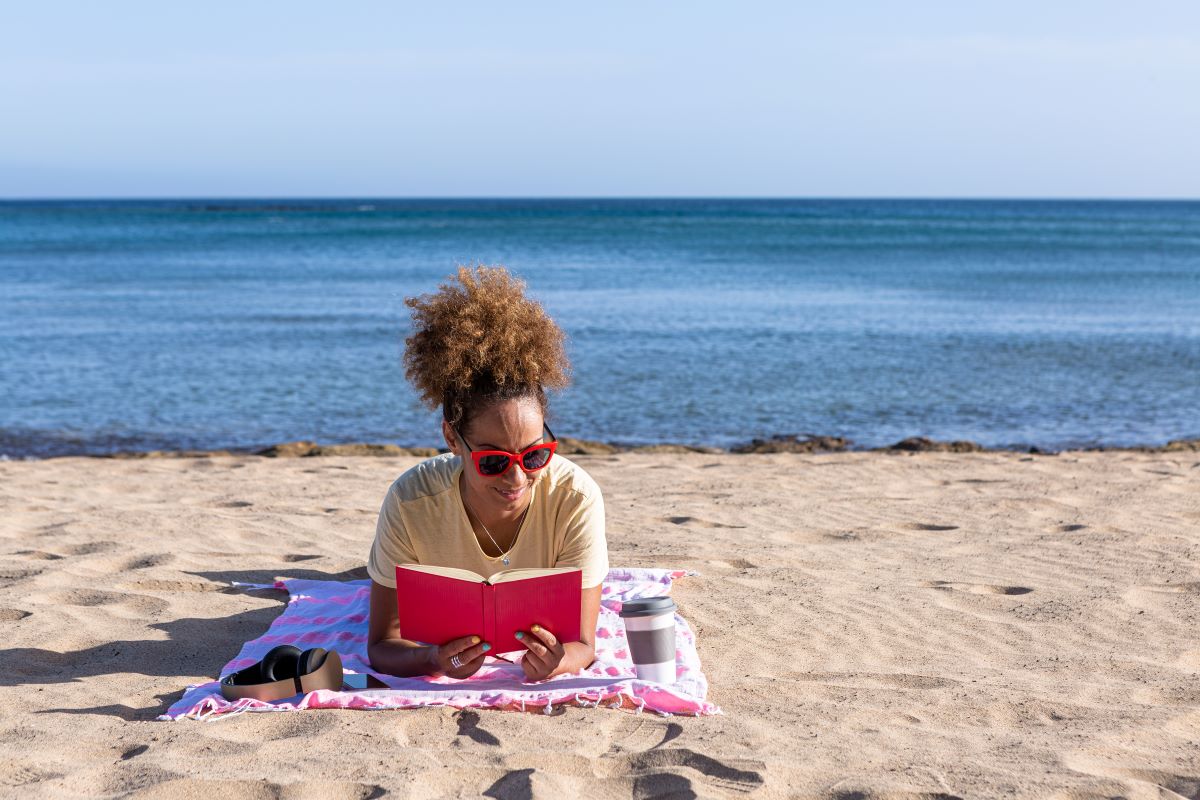 woman reading a book at the beach
