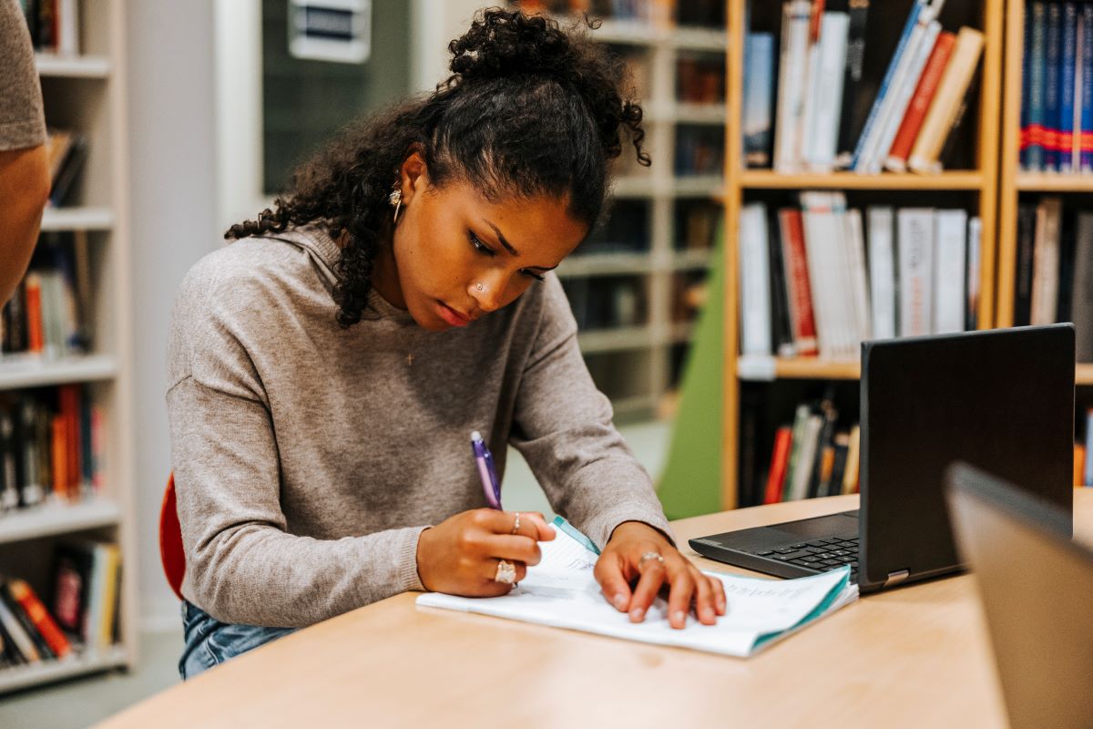 student doing homework at the library